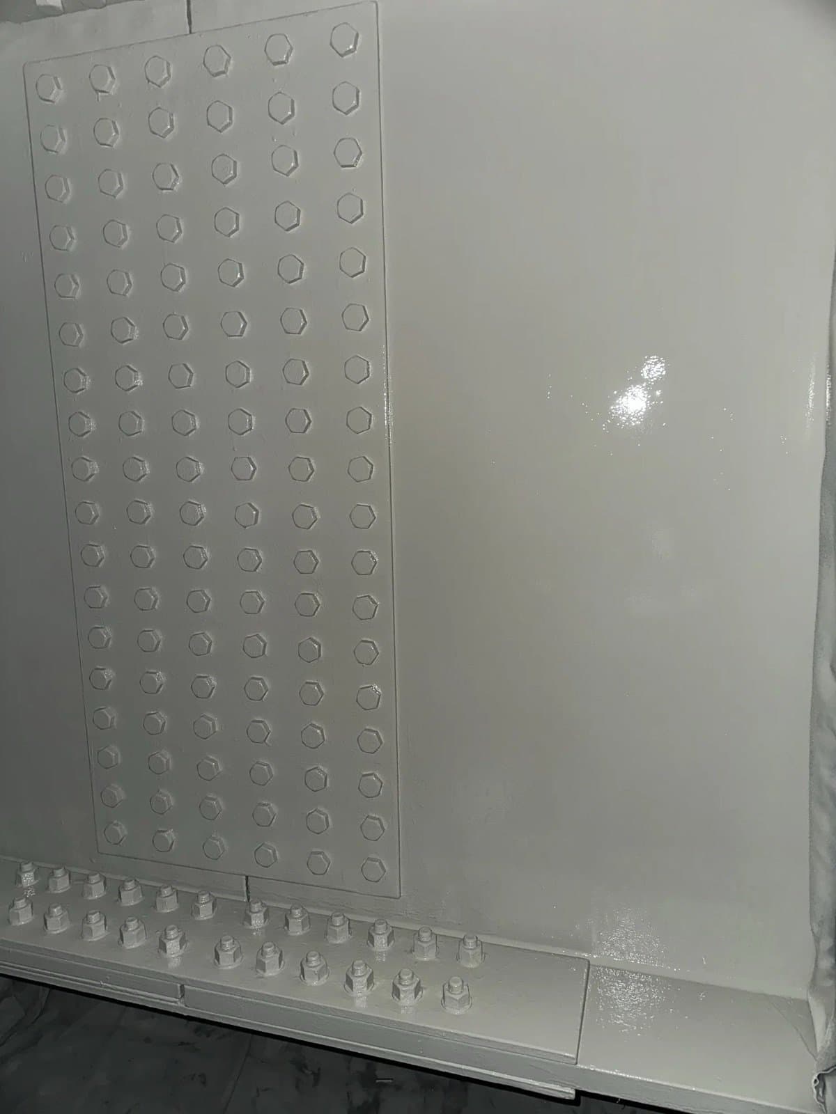 Finished light-grey coating over a bolted steel connection
