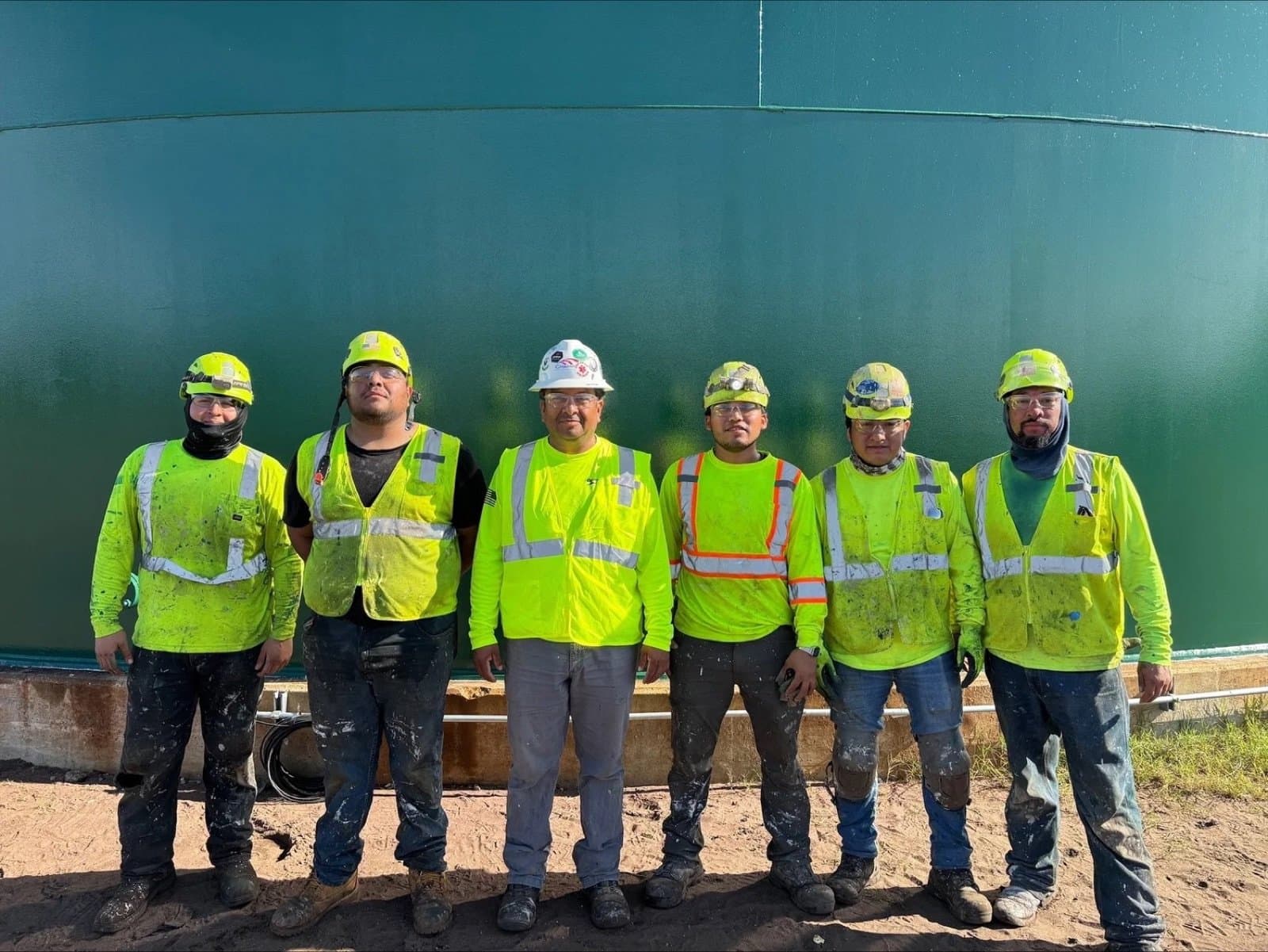 The Gemstone crew in high-visibility gear in front of the finished tank